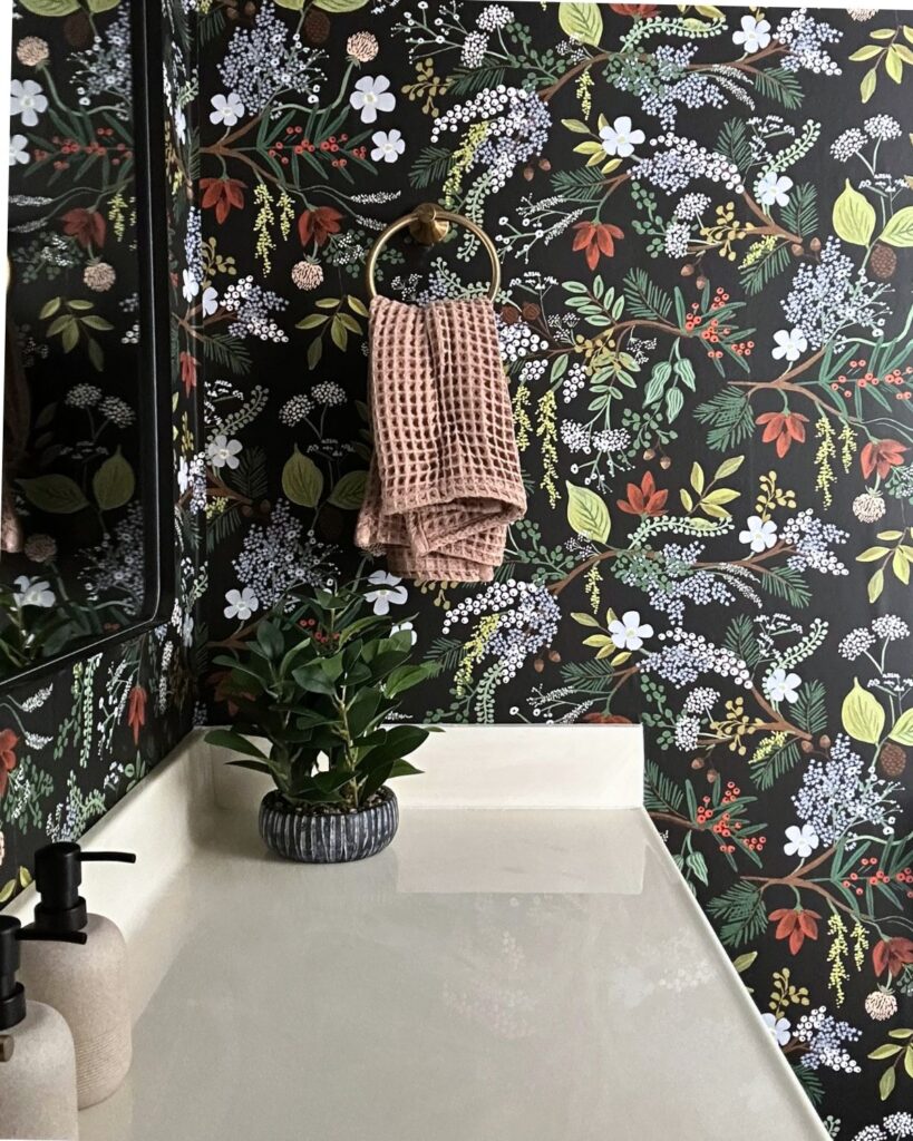 Brass towel ring and textured hand towel against botanical wallpaper in Essex Bath